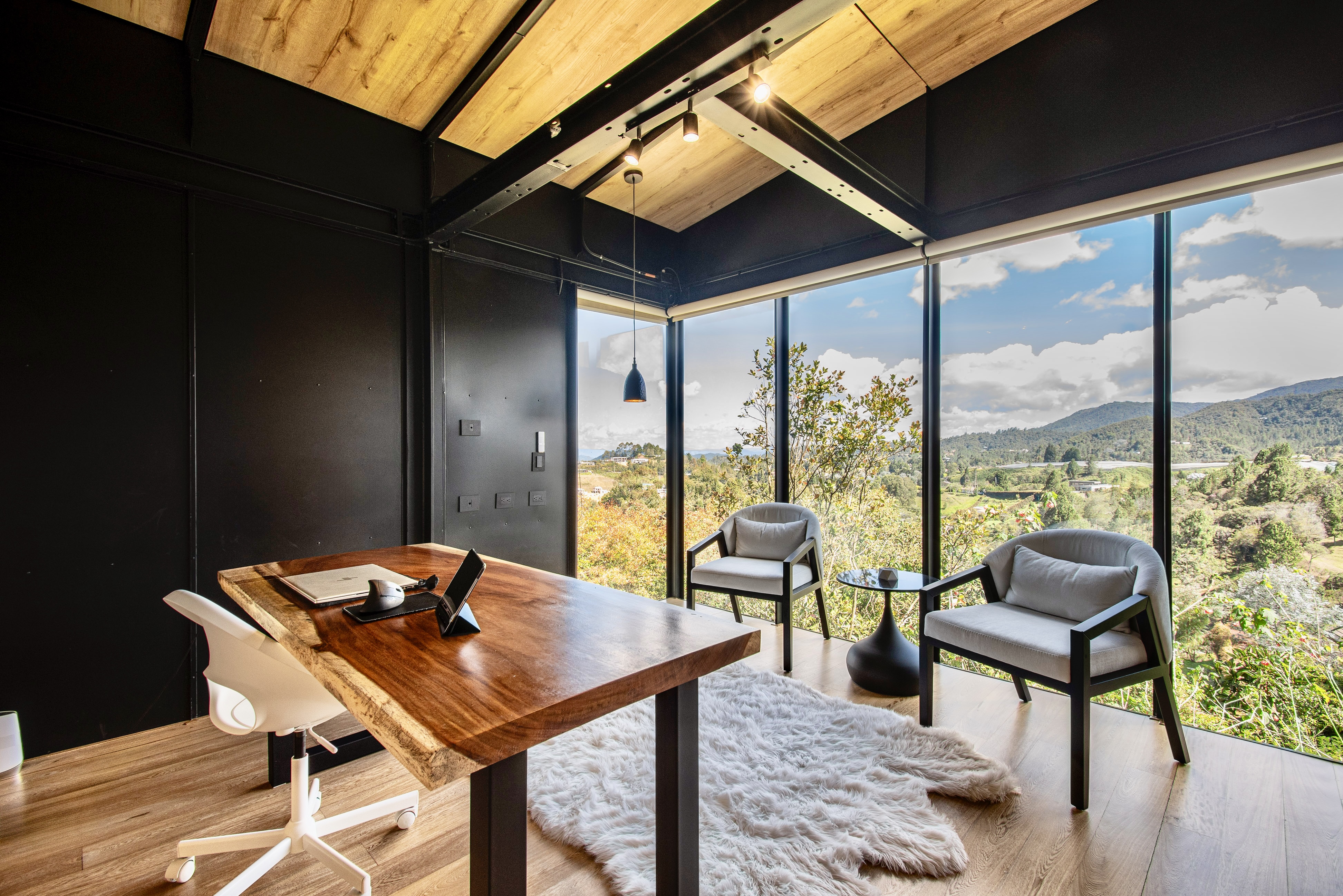 Desk and chairs beside bedroom windows overlooking the garden