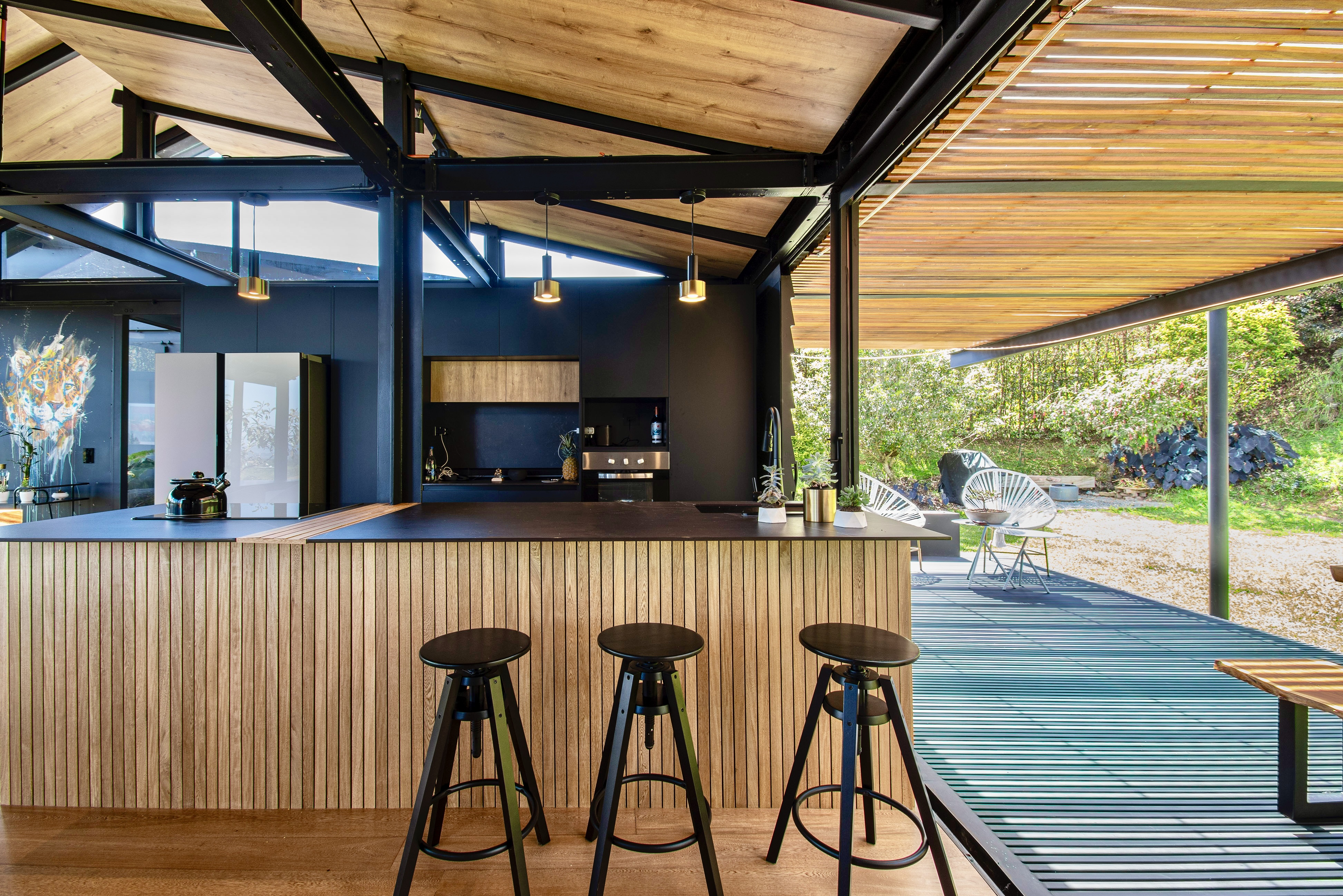 Kitchen island with three stools beside the covered deck