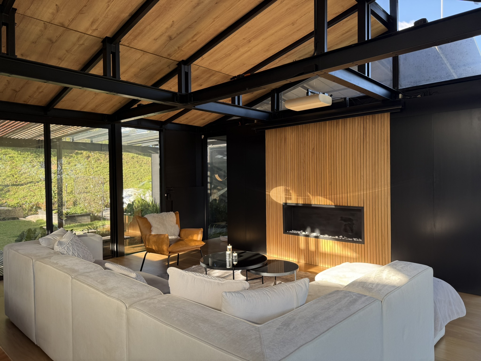 Living room seating facing a wood-clad fireplace wall