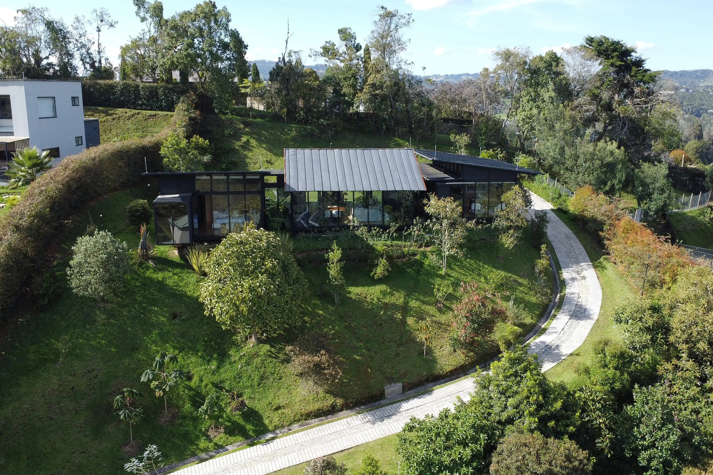 Aerial view of the property, garden and curved driveway