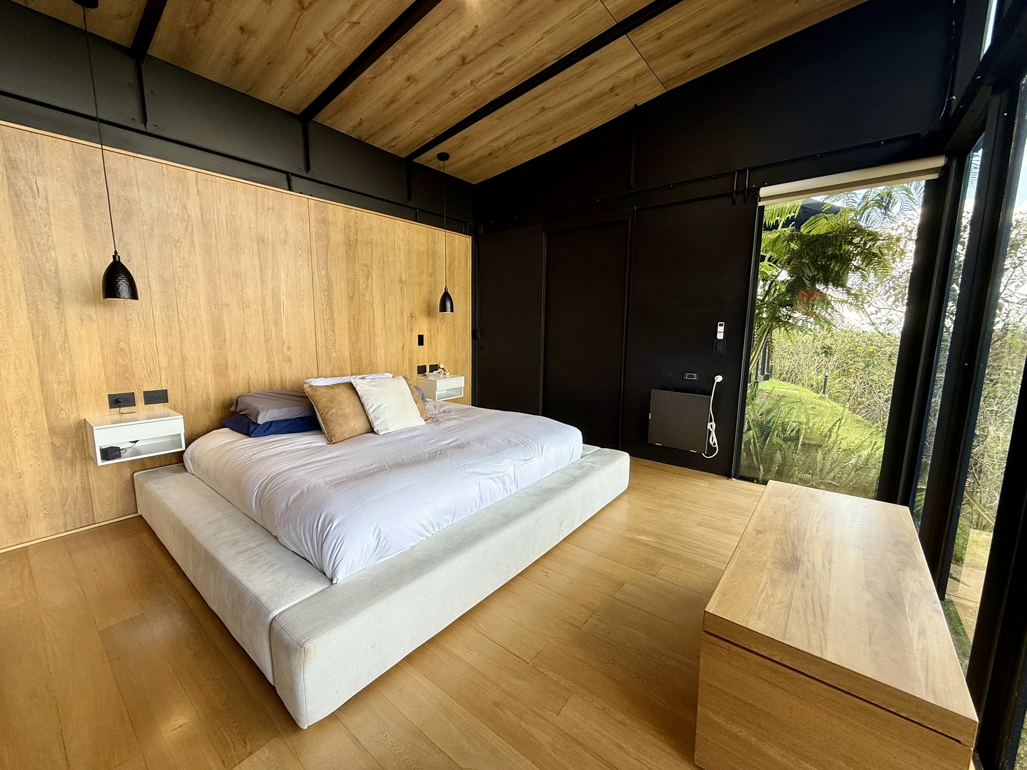 Bedroom with timber walls and a bench at the foot of the bed
