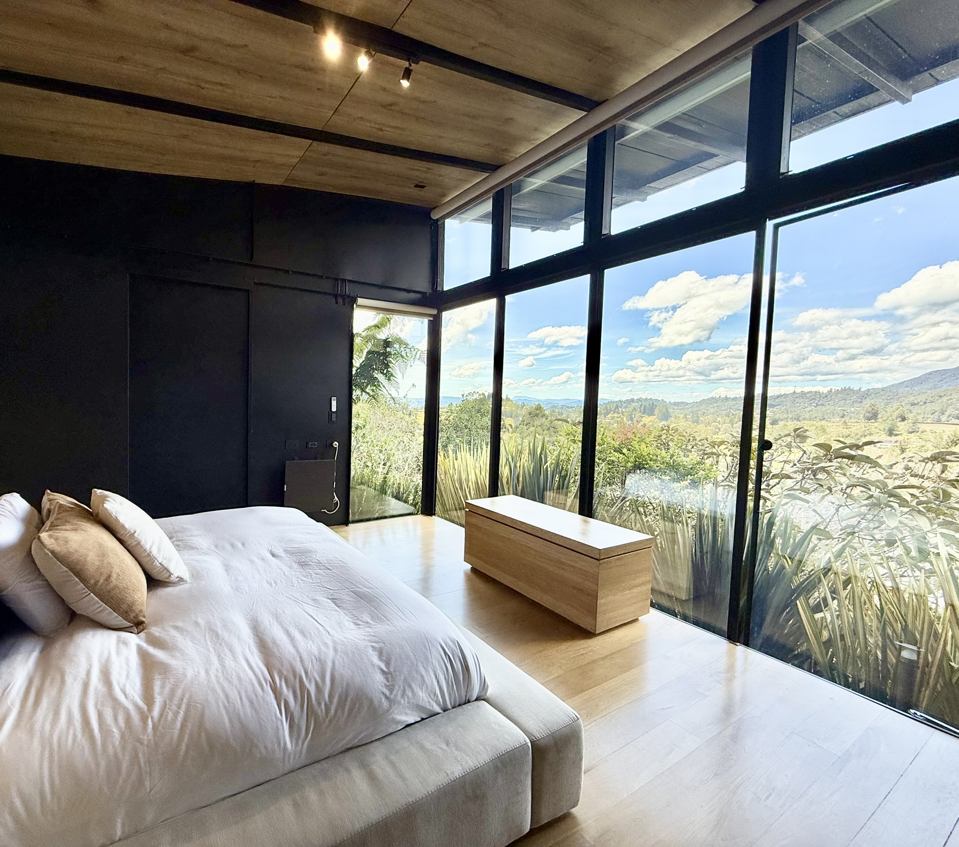 Bedroom with dark walls and windows overlooking the hills