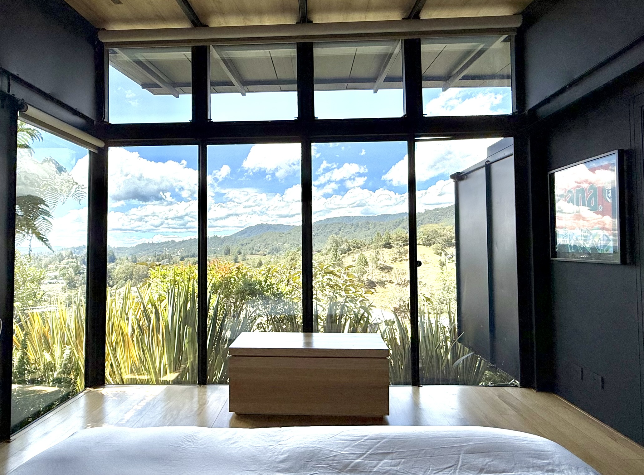 View from a bedroom through full-height windows toward the landscape
