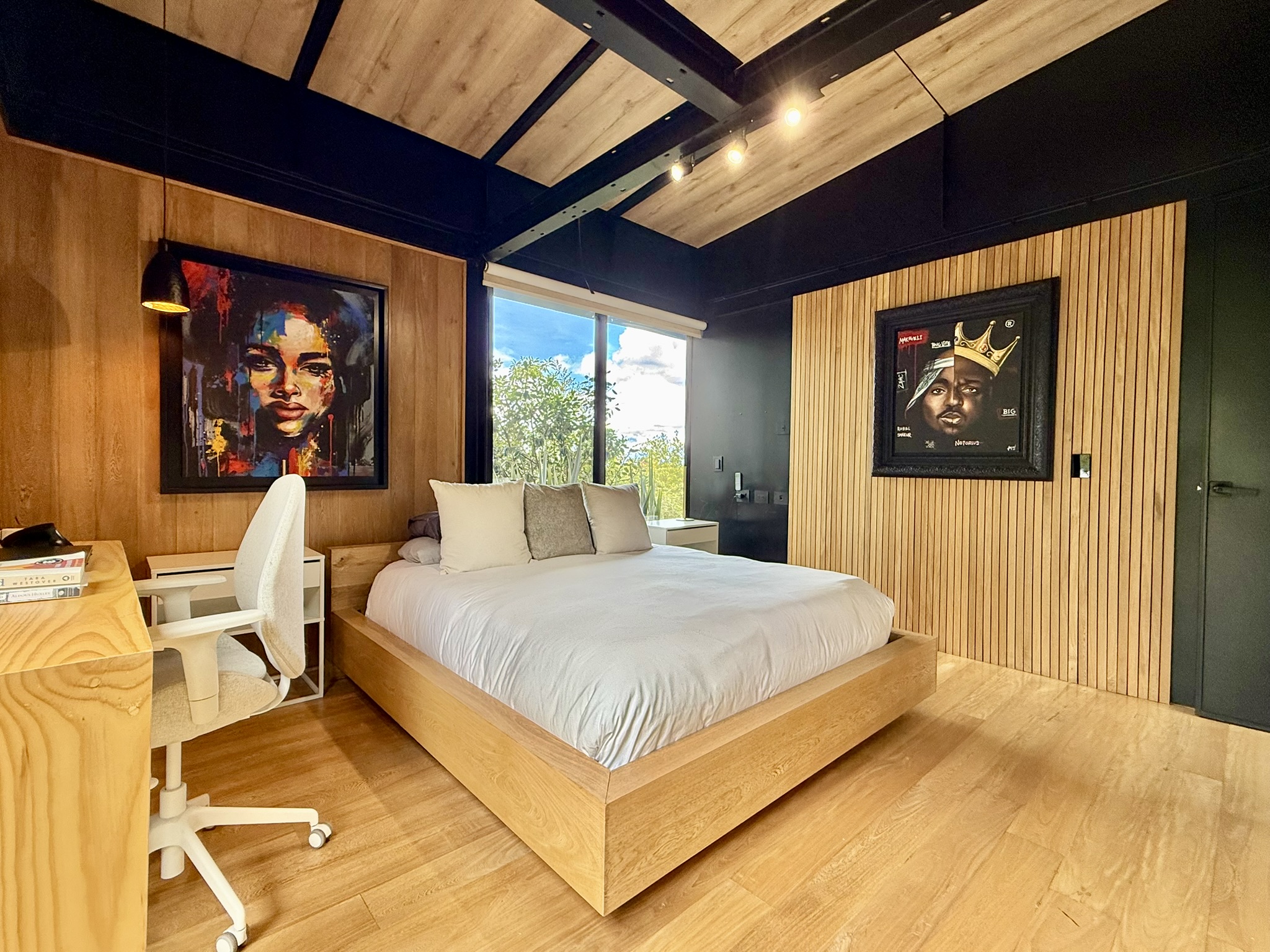 Bedroom with exposed beams, timber headboard and framed artwork